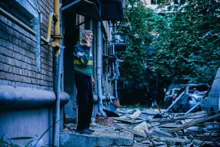 A man stands outside a damaged building
