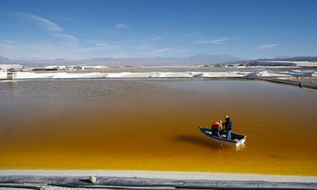 Workers use a boat to take samples from a brine pool at the Rockwood Lithium plant on the Atacama salt flat.