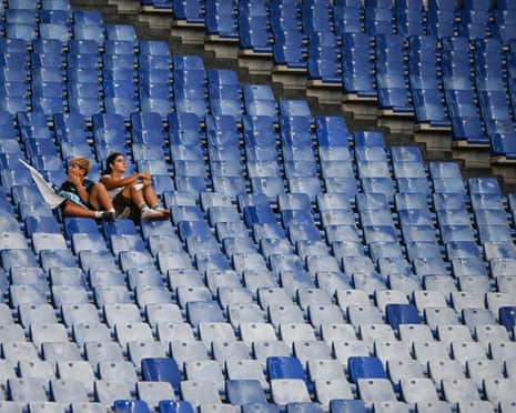 A couple of fans sit among the empty stands due to the protest by Lazio supporters against the club president Claudio Lotito ahead of the Serie A match between Lazio and Genoa