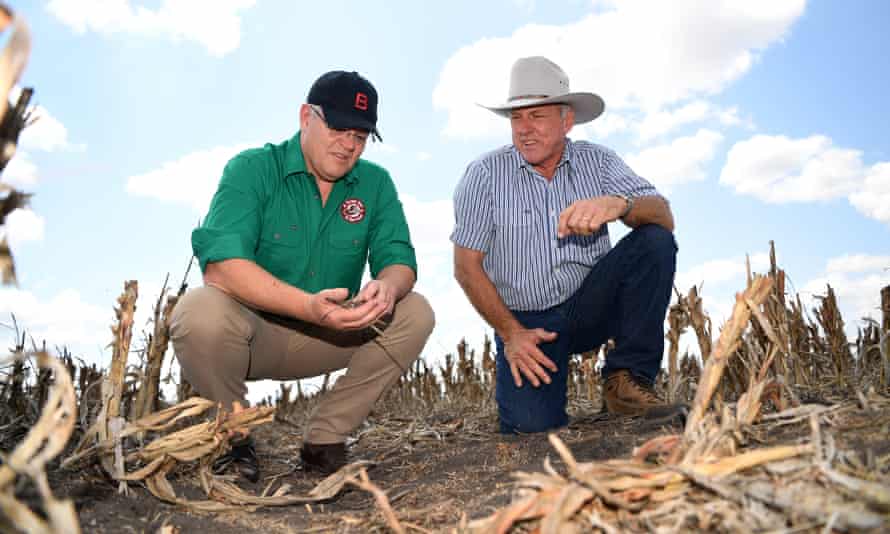 Scott Morrison (left) inspects the dry soil with farmer David Gooding on his drought-affected property near Dalby in Queensland.