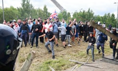 Rioters hurl pieces of wood and other missiles at helmeted police.