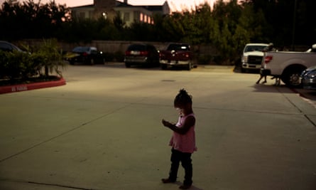 Elizabeth Thomas watches videos on her mother’s phone outside their Fema provided hotel room in Houston on 10 September 2017.