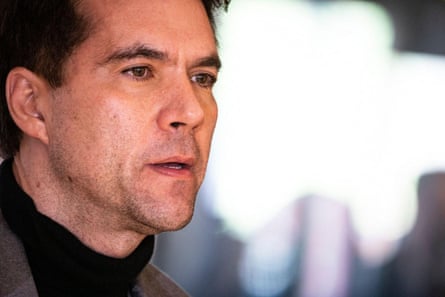 close up of a man in grey suit jacket and black turtleneck at a conference