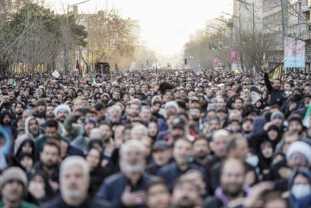 A crowd of people fill the street