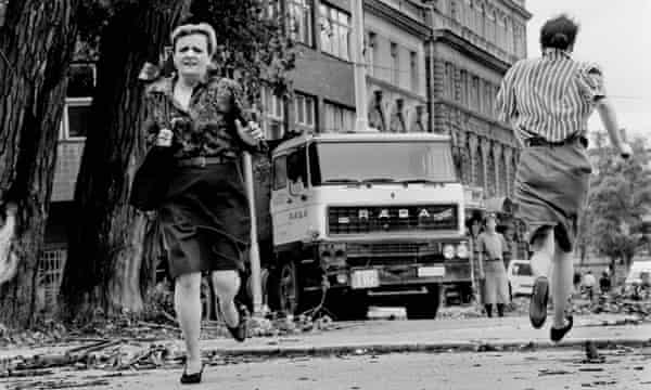 As mulheres correm pelas suas vidas pelo 'beco do atirador furtivo' sob a mira de pistoleiros sérvios durante o cerco de Sarajevo. 1992.