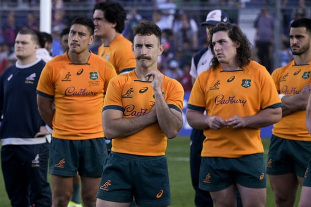 The Australia scrum-half Nic White (centre) and teammates look dejected after defeat.