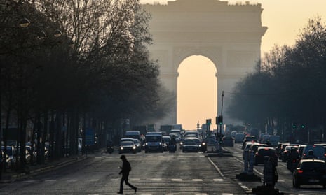 Motorists drive vehicles on the first day of anti-pollution restrictive driving measures, next to the Arc de Triomphe in Paris, on January 23, 2017.