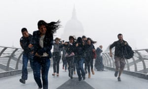 People dash through torrential rain along the Millennium Bridge, Southwark, London, in August 2014.