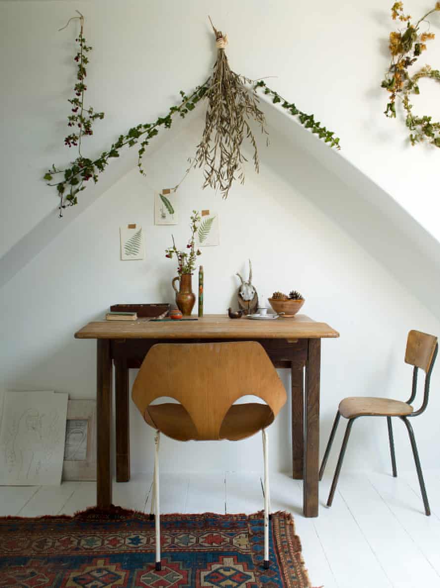 Exploring all the angles: a table and chair under an alcove, with drawings on the wall and Jude’s much loved branches.
