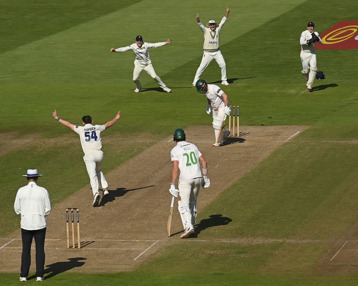 The Warwickshire bowler Ethan Bamber celebrates bowling Leicestershire’s Tom Scrivens to confirm his team as winners of the County Championship.