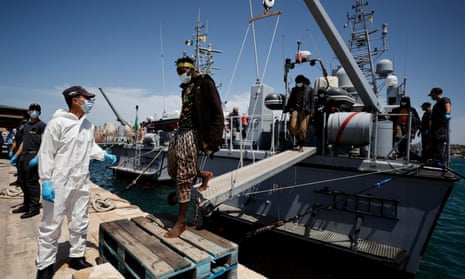 Migrants disembark from a rescue boat at the reception centre on the Italian island of Lampedusa
