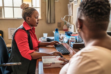 Precious looks on as nurse Samukelisiwe Mamba uses a computer’s keyboard and mouse