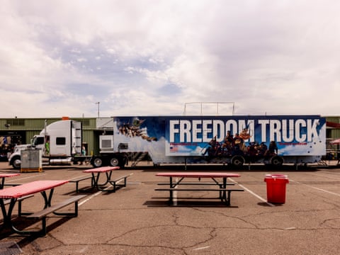 large track marked ‘freedom truck’ parked in lot outside by picnic benches