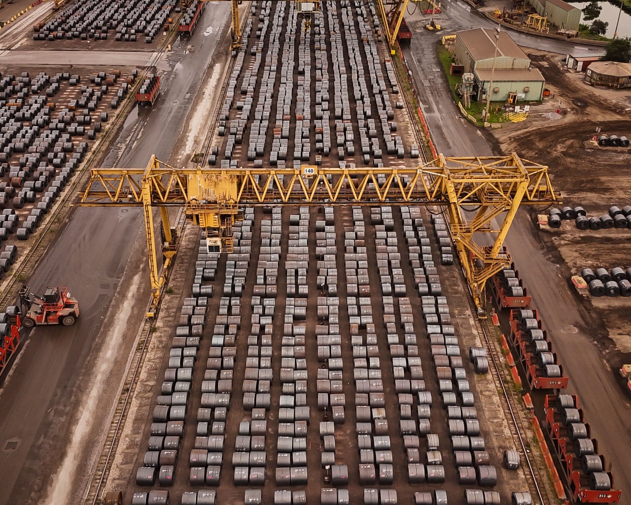 An aerial view of rolled coils of steel in a yard