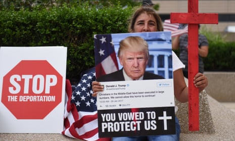 A Chaldean woman holds a photo of Donald Trump during a protest in Detroit.