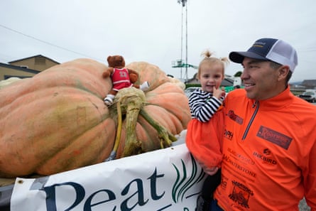 Gienger holds his two-year-old daughter Lily while looking at his pumpkin on Monday.