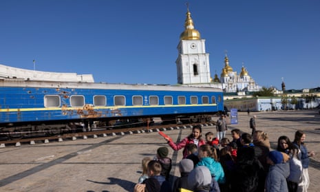 Children look at a war-damaged train carriage on display in St Michael’s Square in Kyiv.