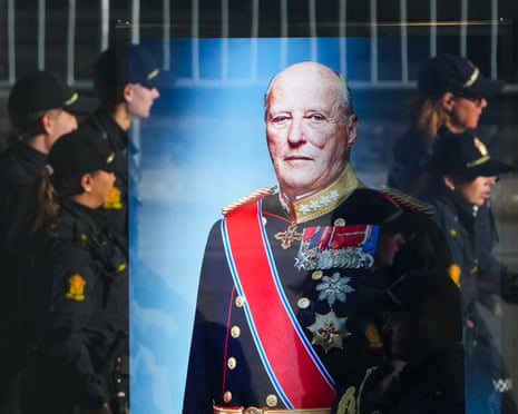 Police officers reflected in a window with a display showing Norway's late King Harald V prior to his funeral in Oslo, Norway.