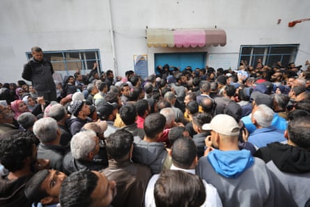 Palestinians gather in front of the Unrwa building in Jabalia to receive flour