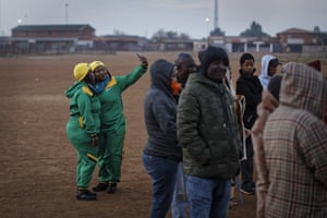 African National Congress supporters take selfies as they queue in the early morning cold in Bekkersdal