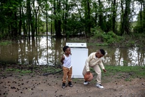 TCHULA, MS - May 9, 2019: August Watts, 3, and his cousin Jaikeem, 7, play with a ball that had been floating in the floodwaters in their backyard. Andrea Morales for The Guardian