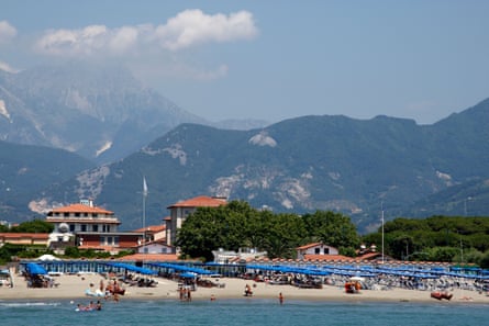 The main beach at Forte dei Marmi in Tuscany with sunloungers and umbrellas with tuscan hill in the background