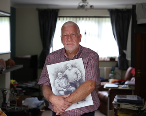 Chris Farrell holds a portrait in his living room