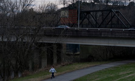 A woman walks near an American flag made of lights on a bridge in Rome, Georgia.