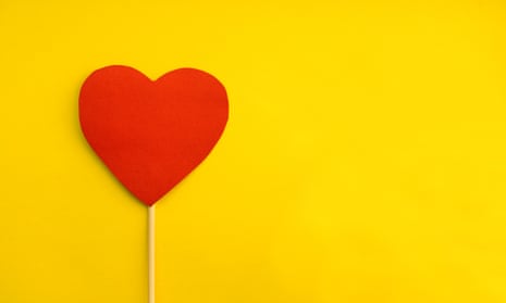 Red paper heart on yellow background