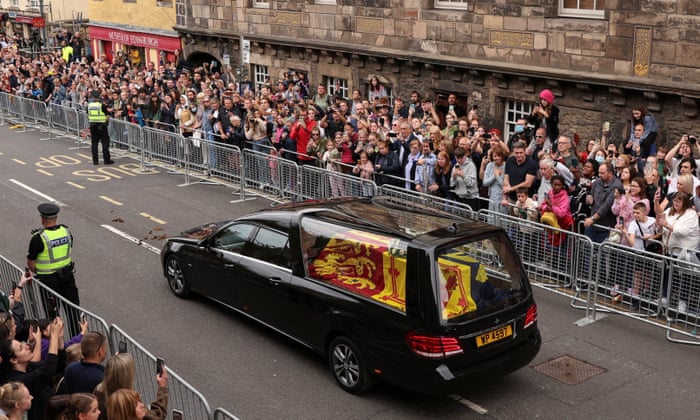 People watch the hearse carrying the coffin of Queen Elizabeth II on the streets of Edinburgh.