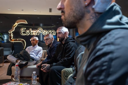A group of men with bandaged heads sit on a sofa