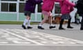 Children follow each other in a line while playing in a playground