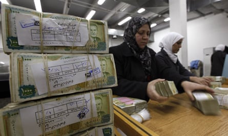 Syrian central bank staff stack wads of Syrian pounds in Damascus
