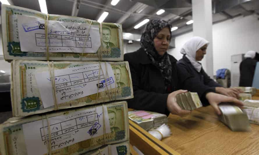 Syrian cardinal slope unit stack wads of Syrian pounds successful Damascus