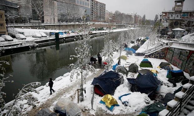 Migrants at a makeshift camp blanketed by snow at the Saint-Martin canal in Paris.