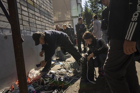 People charge their phones and electronic devices powered by a generator in the recently retaken area of Izium.