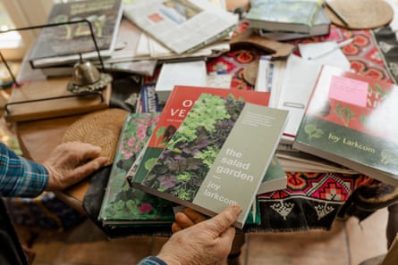 Larkcom is the author of several influential books on growing vegetables; in this photo she holds some of them up to the camera.
