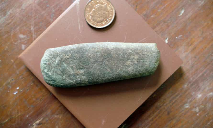 A flat rectangular stone, placed next to a 2p piece for scale
