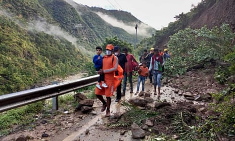 Disaster response workers rescue people stranded following heavy rains at Chhara village near Nainital.