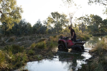 Jonathon Guyer crossing a creek on a quad bike