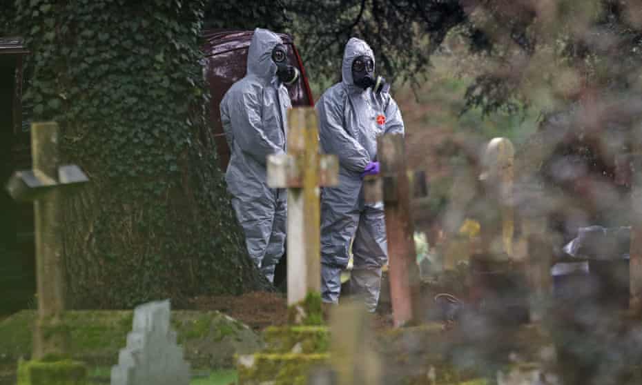 Forensic officers wear gas masks at the cemetery in Salisbury, Wiltshire, where the wife and son of the former Russian double agent Sergei Skripal were laid to rest. 