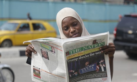 A muslim woman reads a newspaper on a street in Lagos, Nigeria.