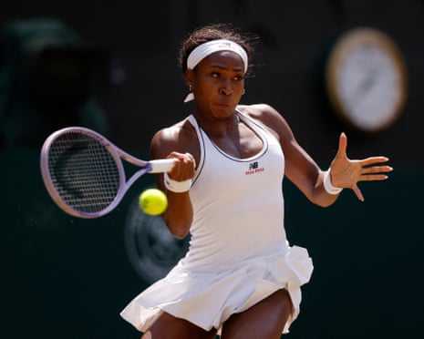 Coco Gauff in white outfit hits a forehand shot on a grass court