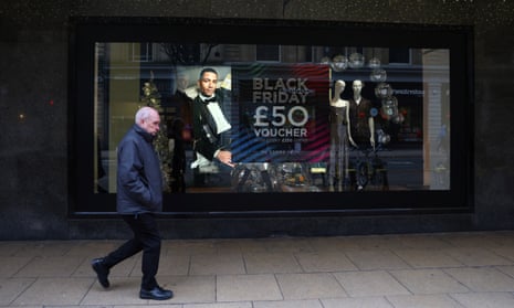 A man walks past a Black Friday signage displayed on the window of House of Fraser in Manchester in November.