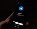 Telegram app login screen is shown on a smartphone.