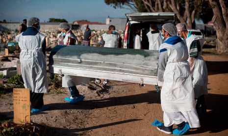 Mourners in personal protective equipment carry the coffin of a Cape Town taxi driver who died of Covid-19.