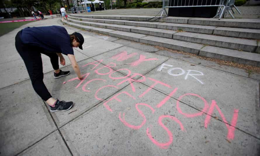 An abortion rights protester writes on the sidewalk in New York city