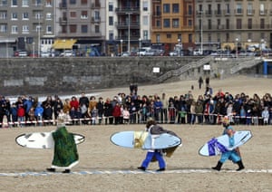 Men dressed as the three wise men arrive with surfboards at La Zurriola beach before the traditional parade in San Sebastian, Basque country