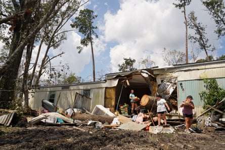 People clean out a storm damaged hom in Springfield, Louisiana.