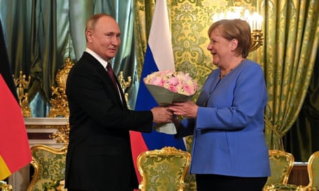 President Vladimir Putin presents flowers to German Chancellor Angela Merkel during their meeting at the Kremlin on 20 August 2021. 